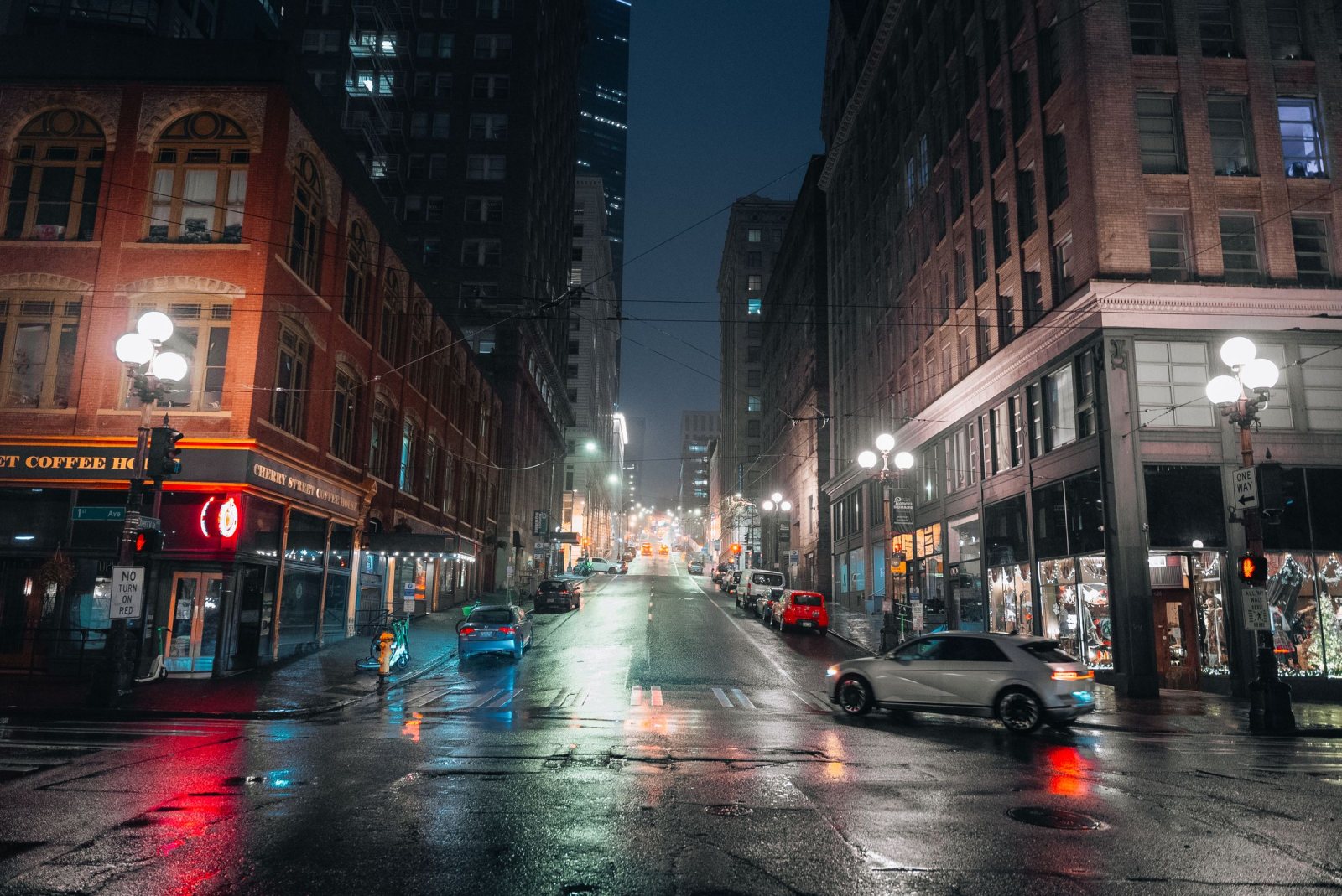Rainy night on a street in Seattle’s Pioneer Square, lit by street lamps and shop windows